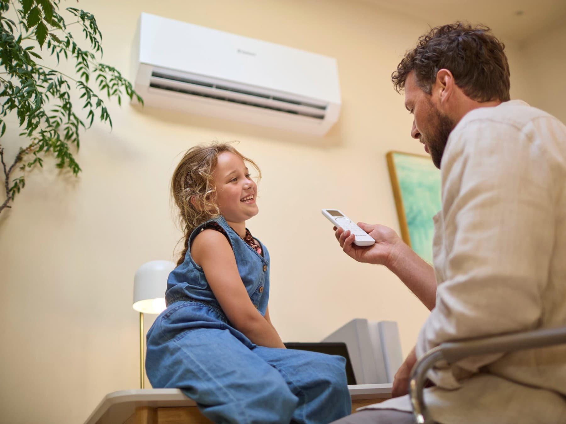 Père et enfant assis sous la climatisation