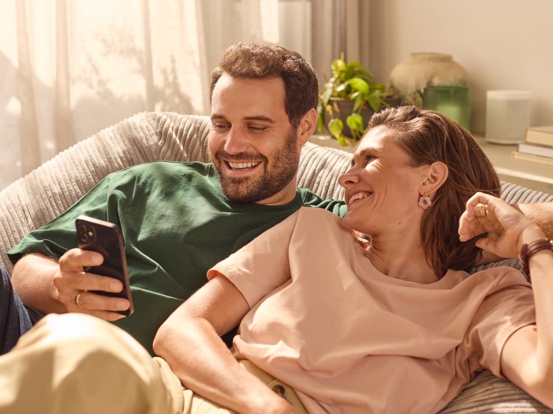 Couple sitting on the sofa checking energy consumption on an app