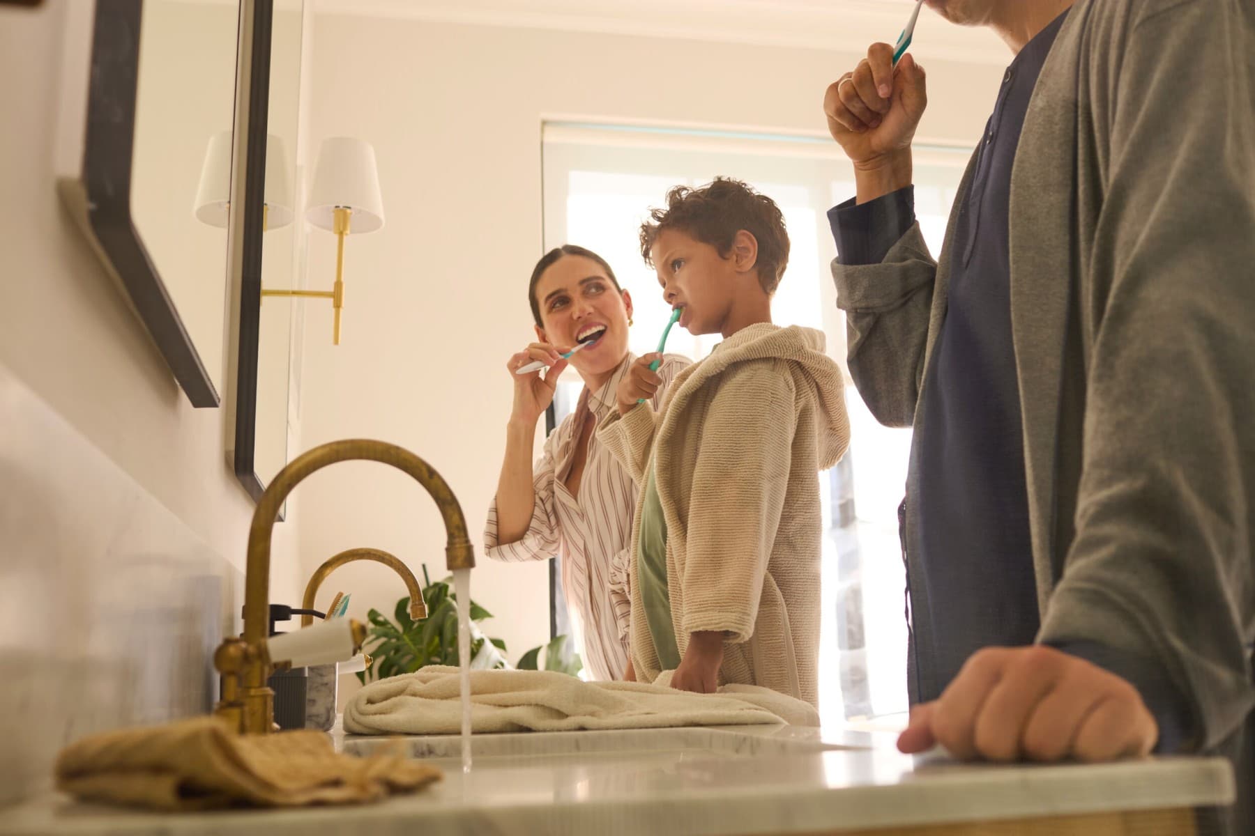a family is brushing their teeth in the bathroom