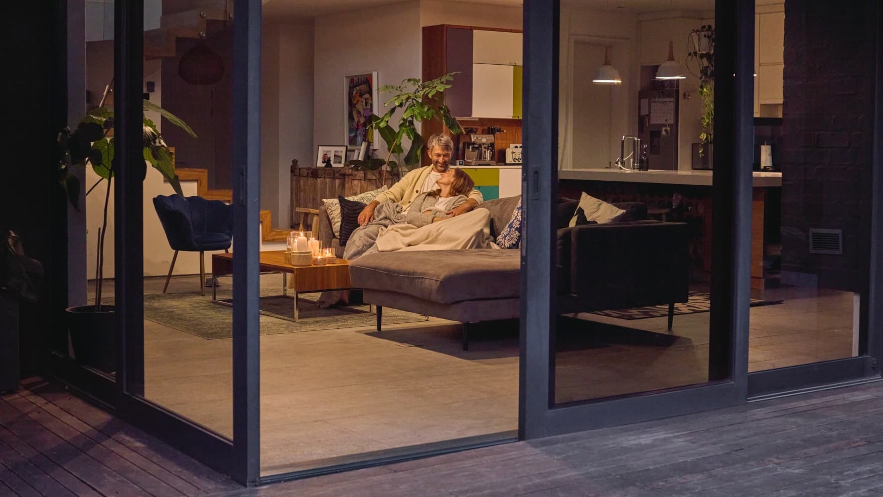 Couple sitting on the sofa with the patio door open