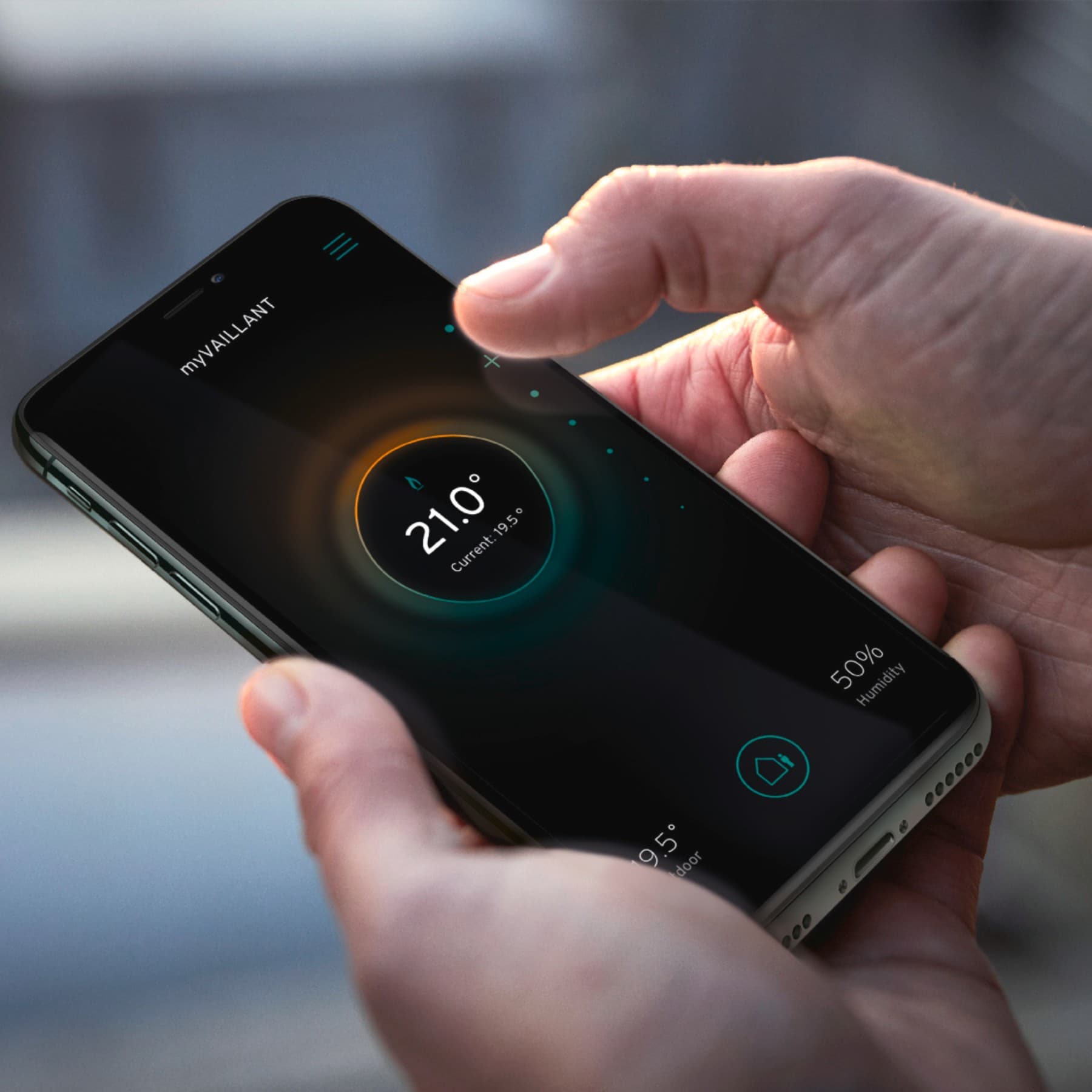 Hand using smart phone to controle his heating
