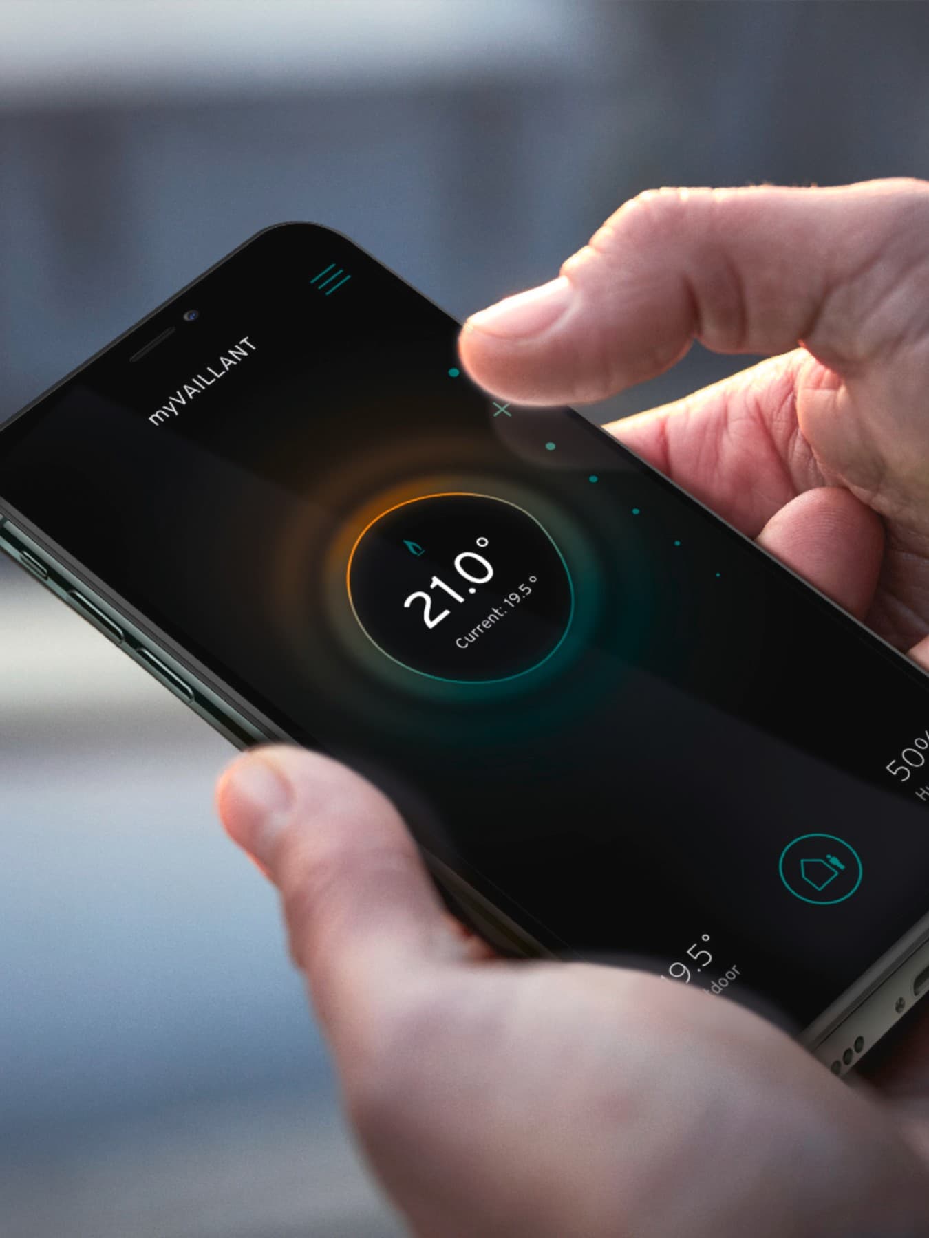 Hand using smart phone to controle his heating