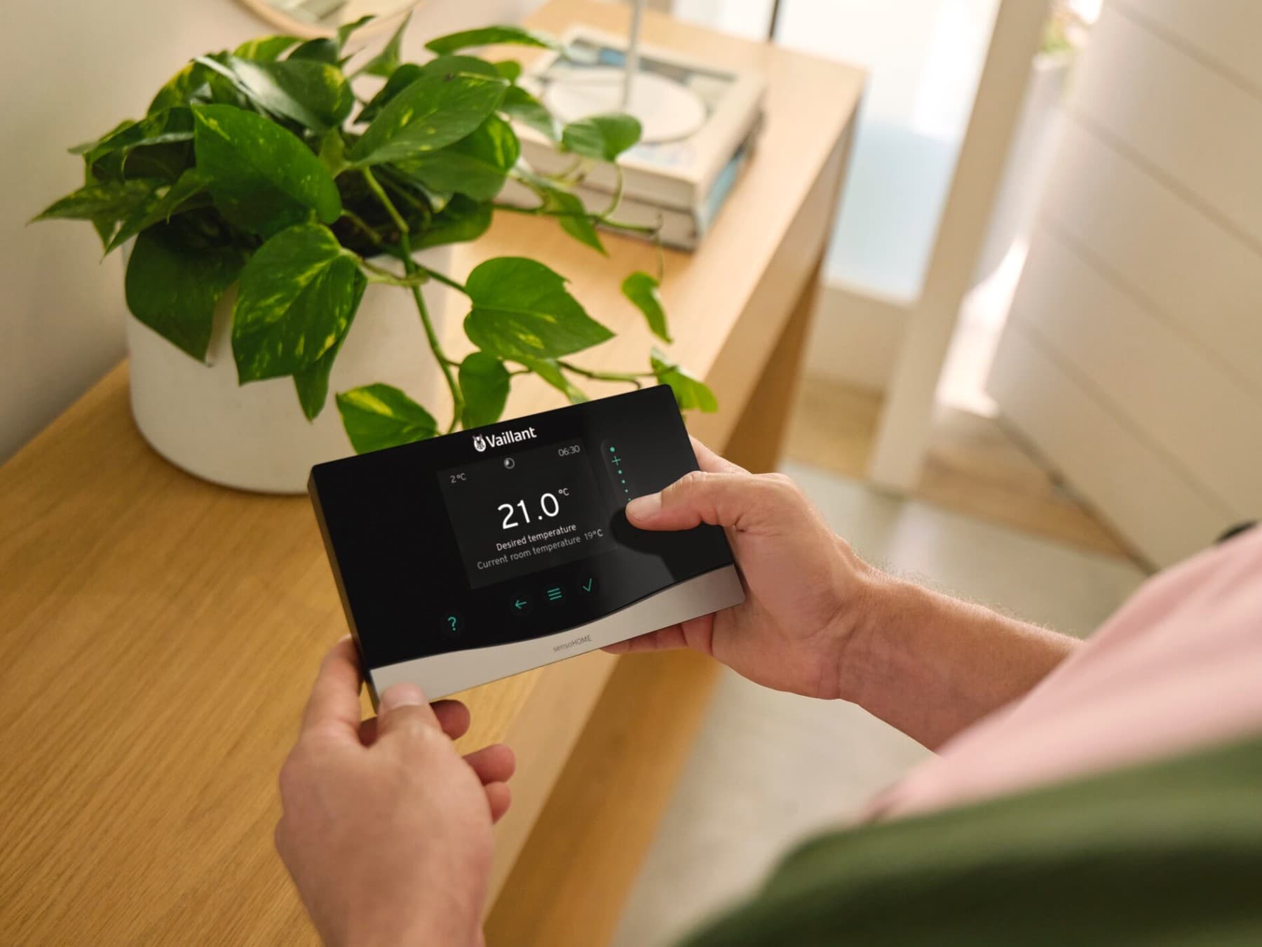 Man holding the system control sensoCOMFORT in his hand