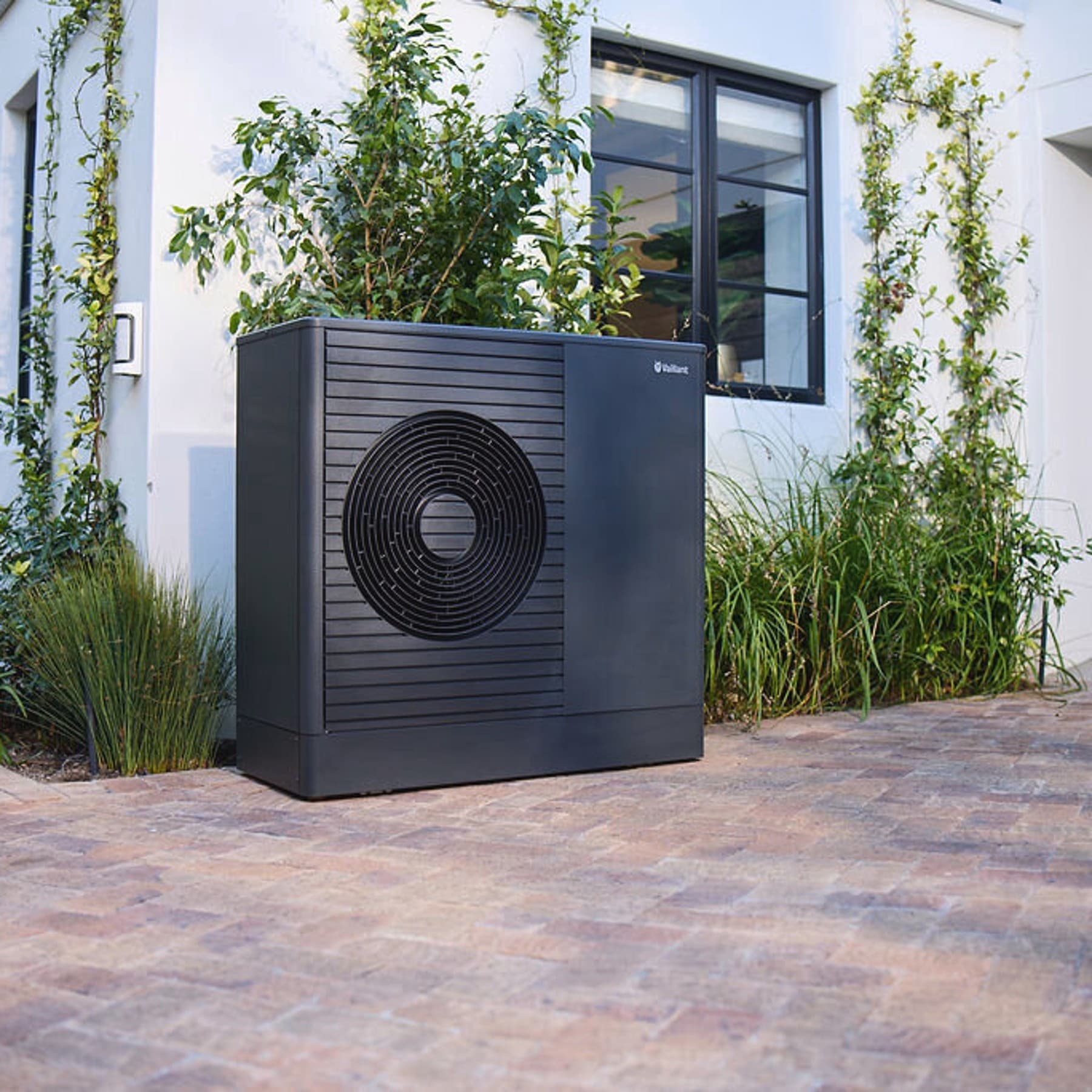 Dark Vaillant aroTHERM plus heat pump in the front garden of a house