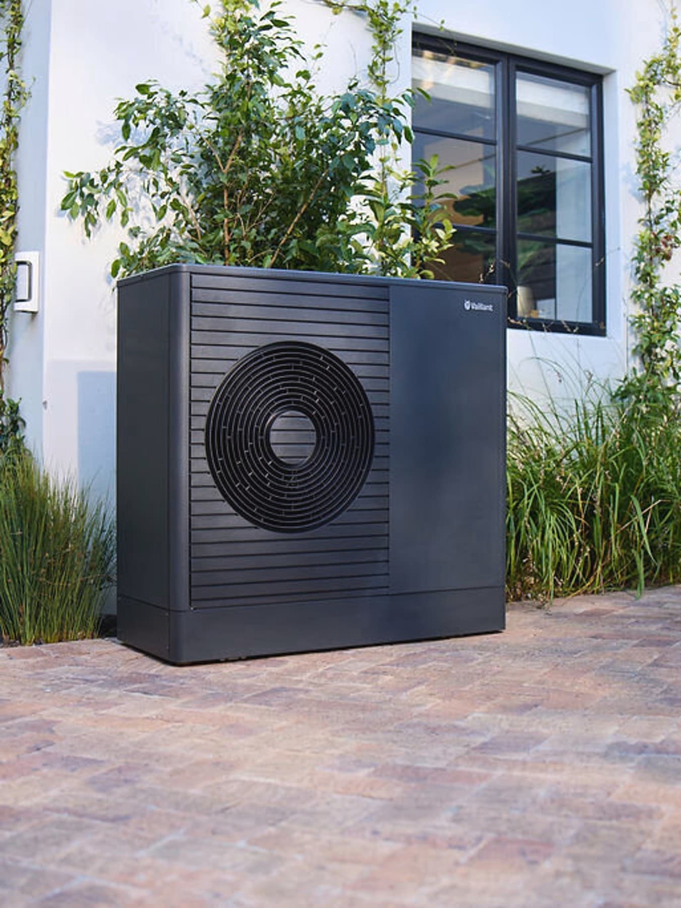 Dark Vaillant aroTHERM plus heat pump in the front garden of a house