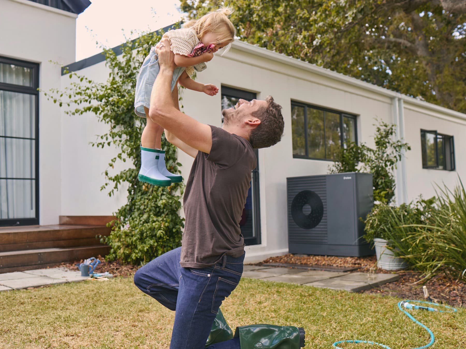 Father plays with his daughter in the garden.