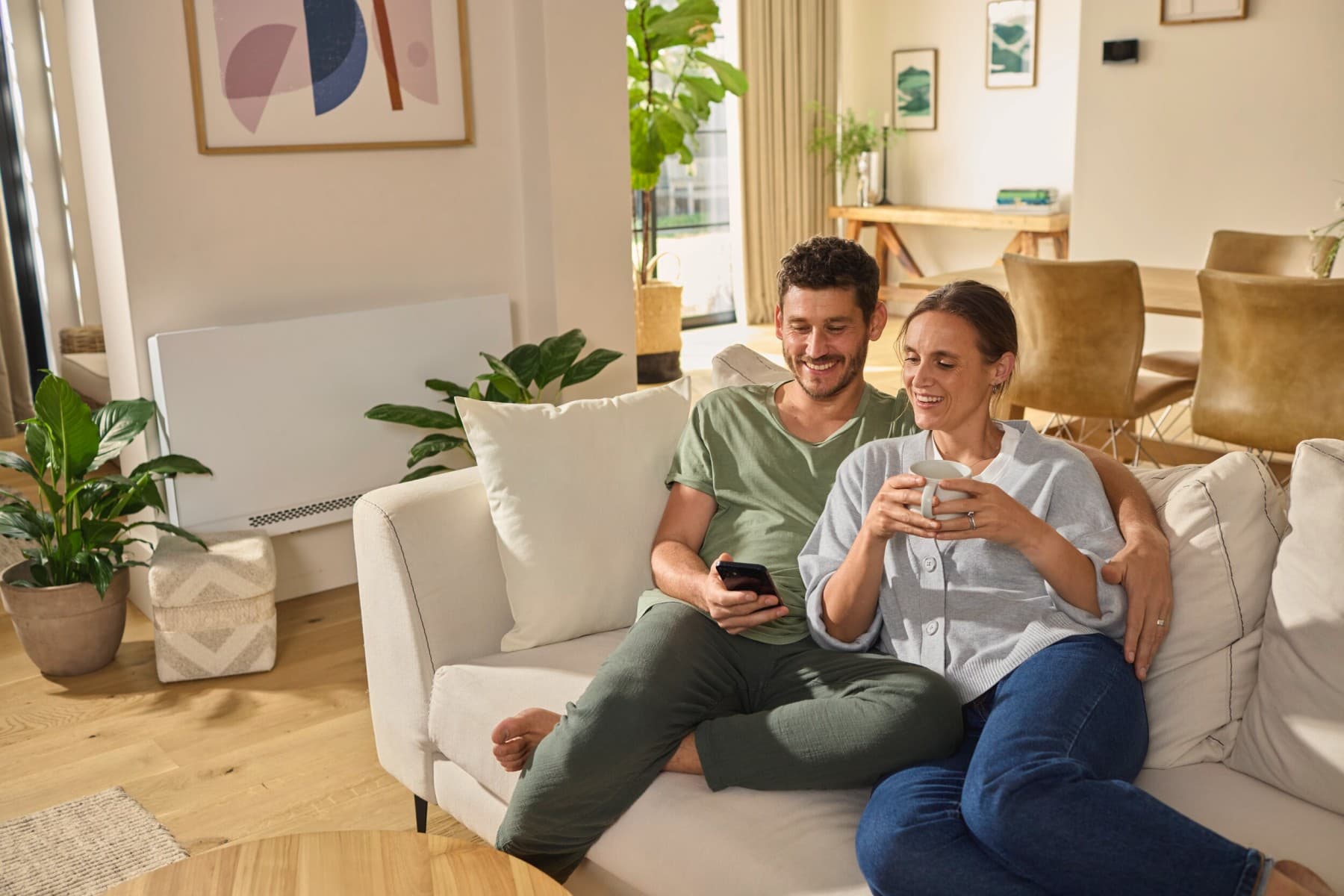 Couple sitting on the sofa looking at a smartphone