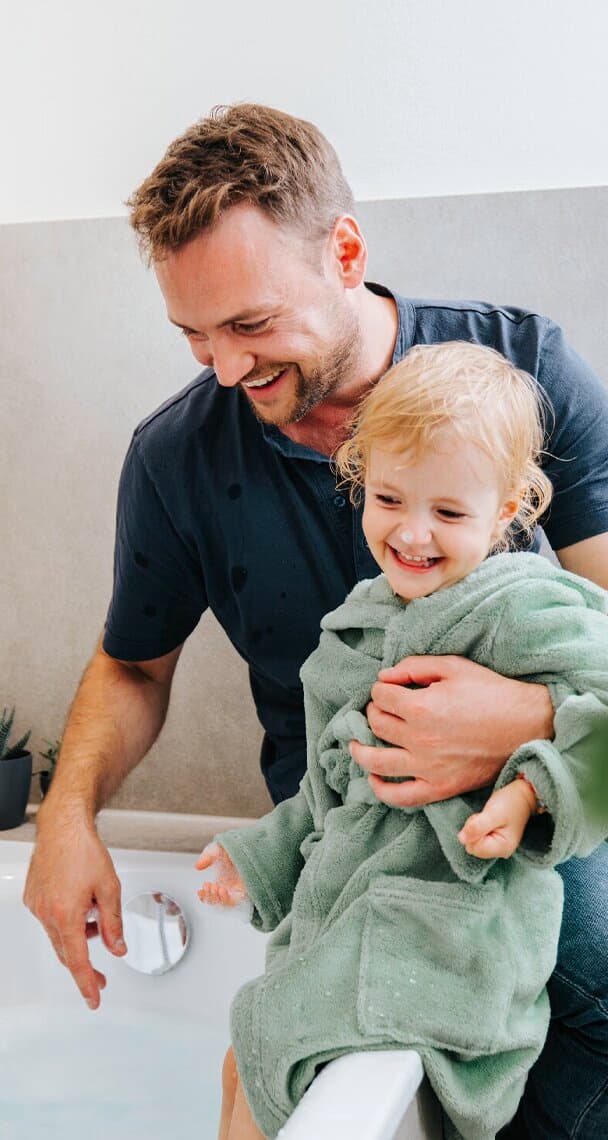 Father and child sitting at bathtub.