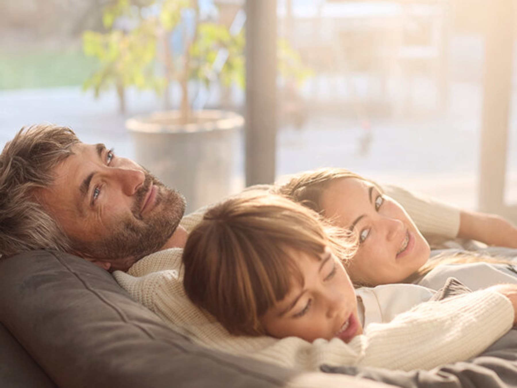 A family is lying on the sofa
