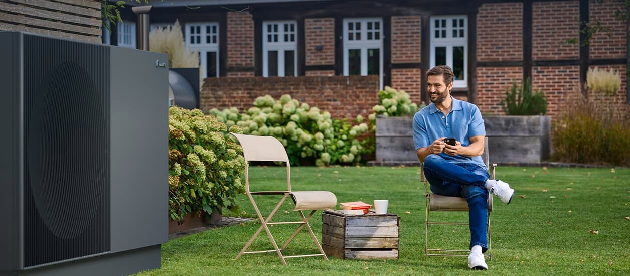 Man sitting next to aroTHERM perform in the garden
