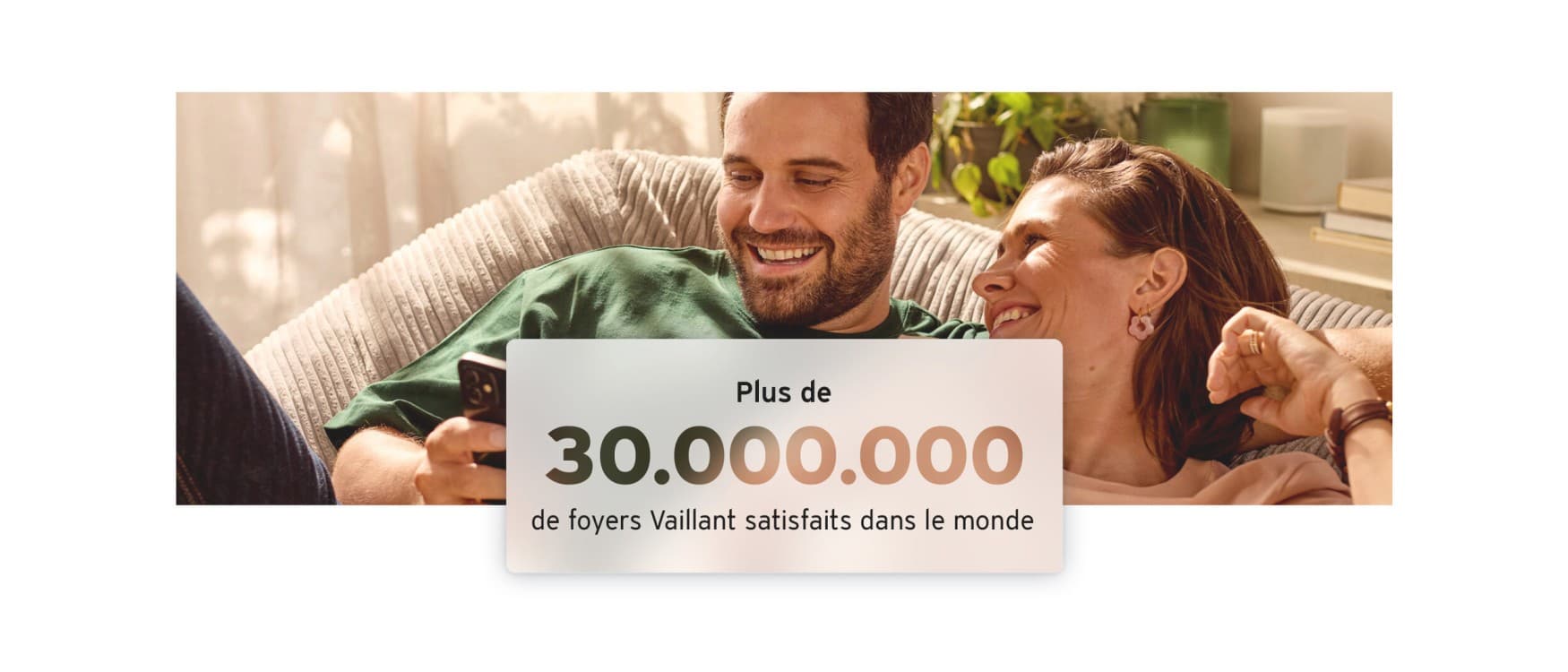 Un couple assis en terrasse devant une pompe à chaleur