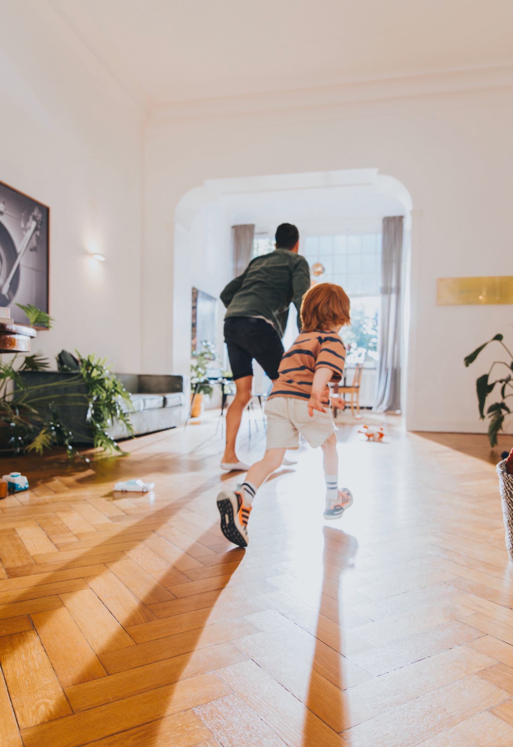 Man playing with his child in the living room.