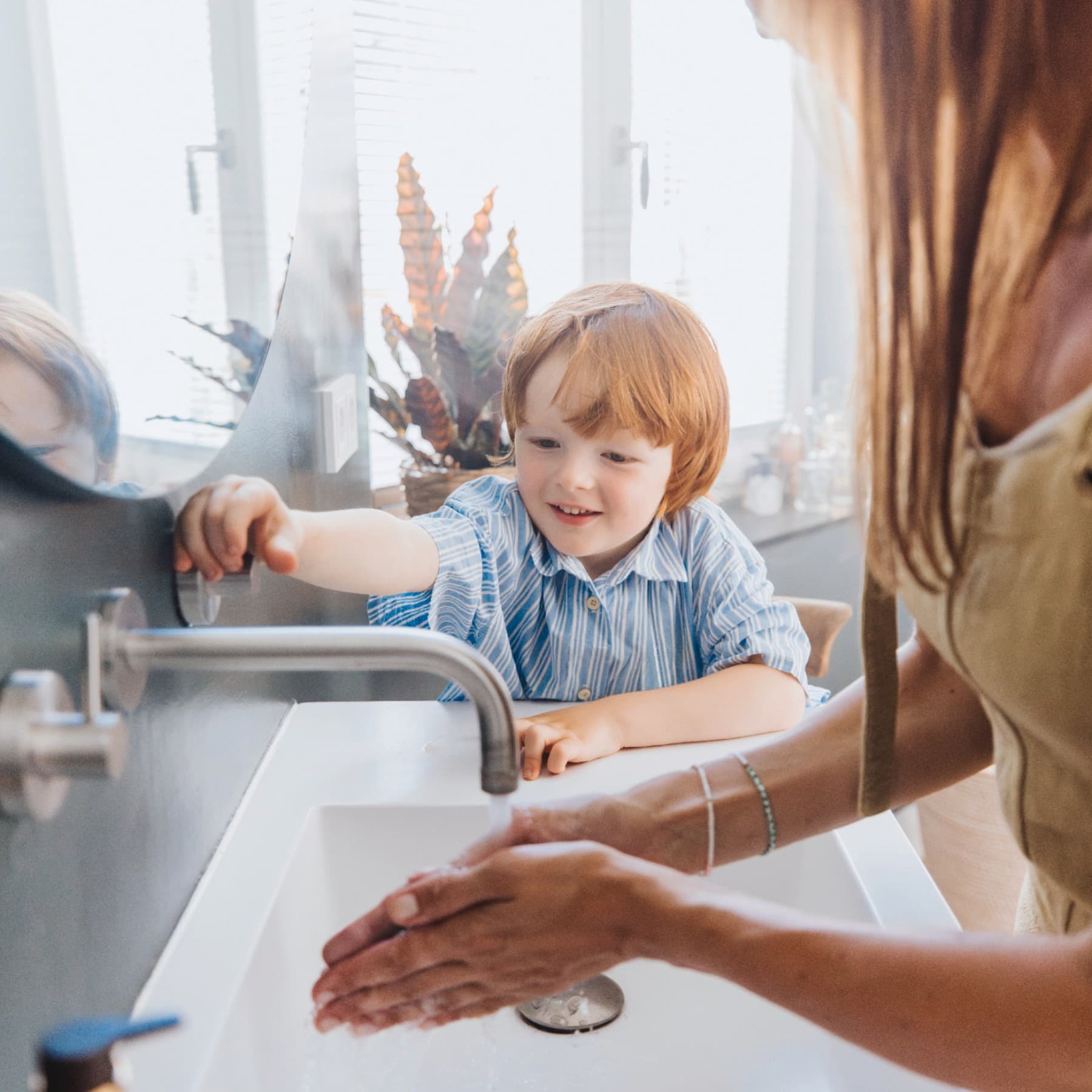 Un garçon et sa mère se lavant les mains
