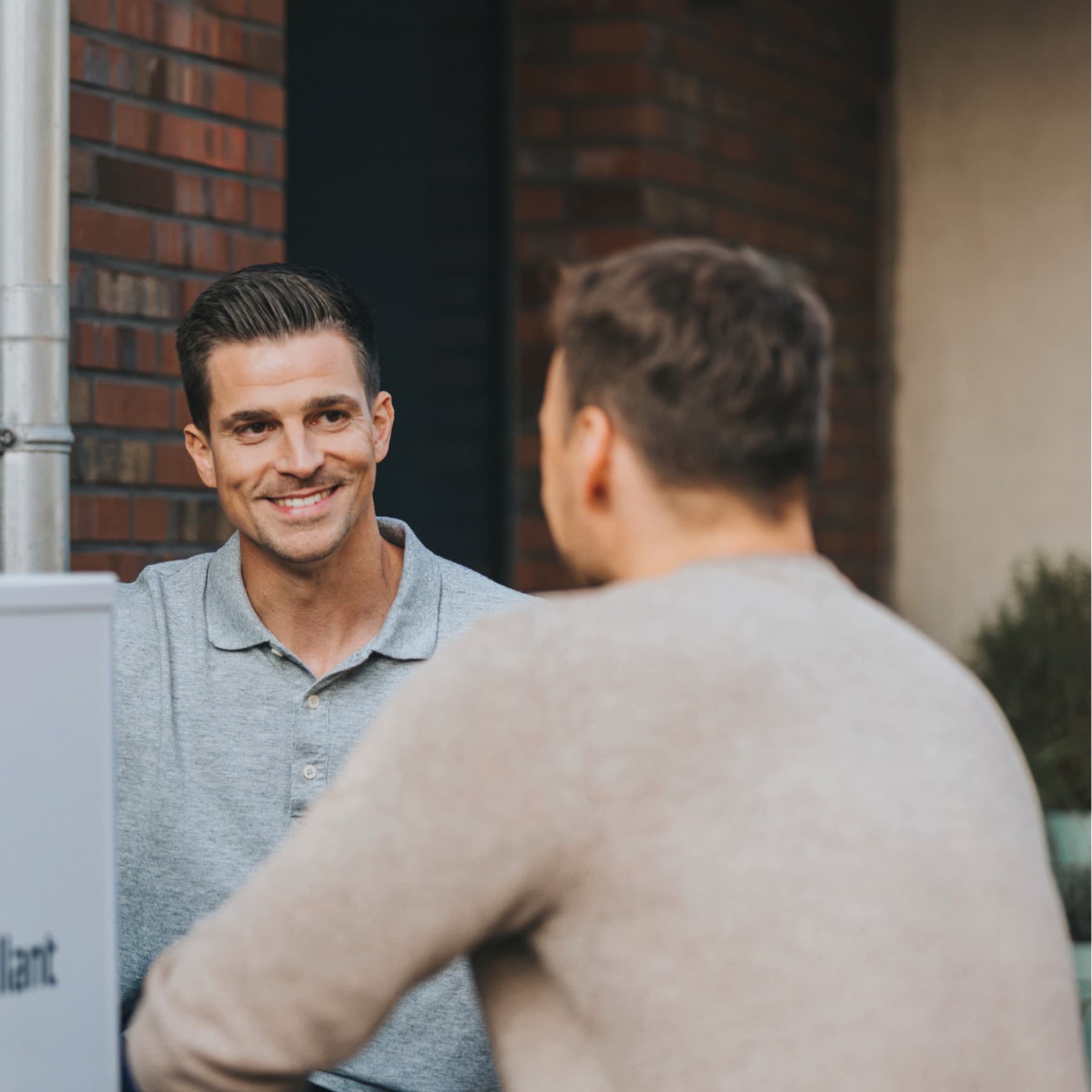 An installer and a customer in front of a heat pump