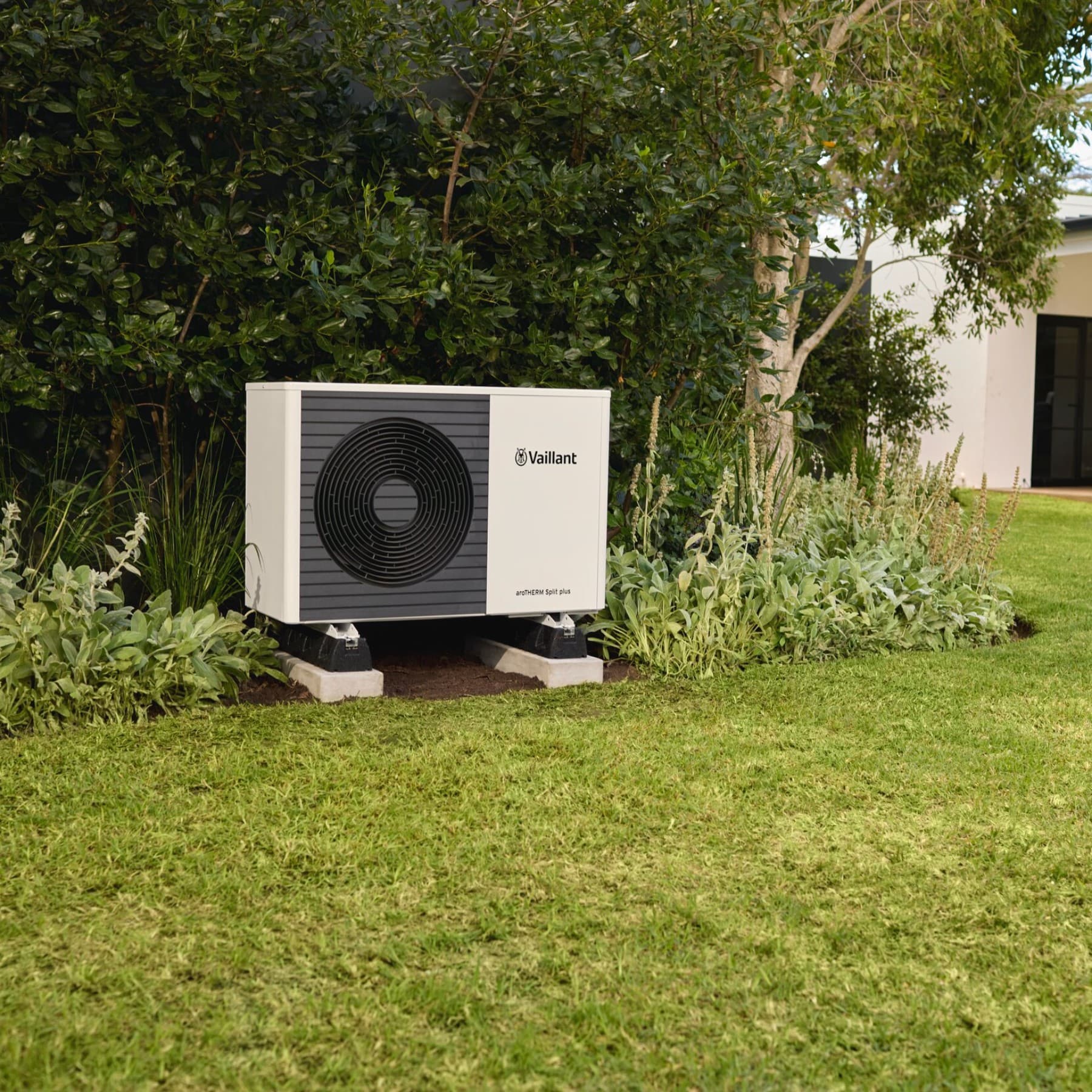 A heat pump outdoor unit in a garden
