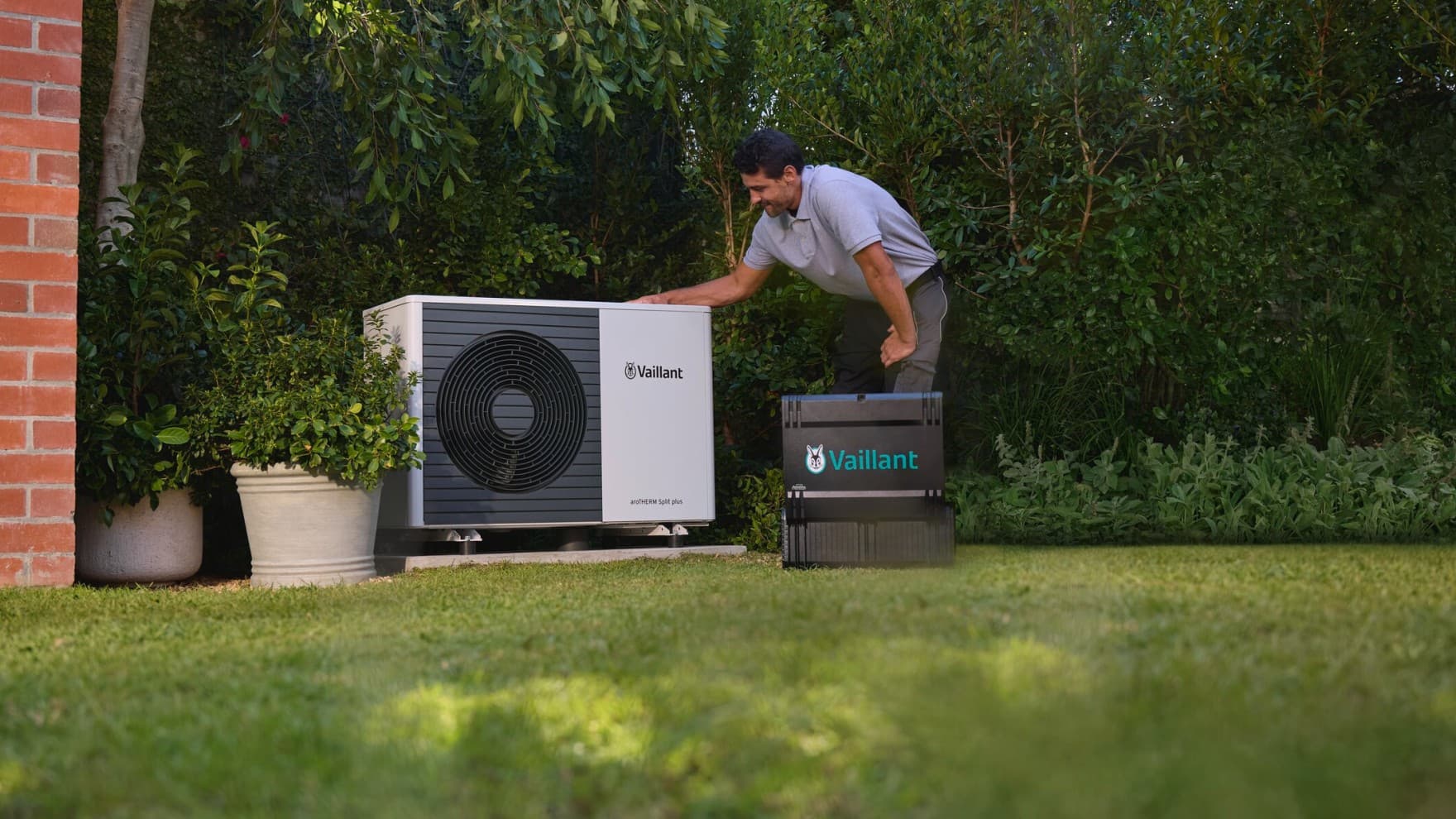 Installers positioning air source heat pump into place