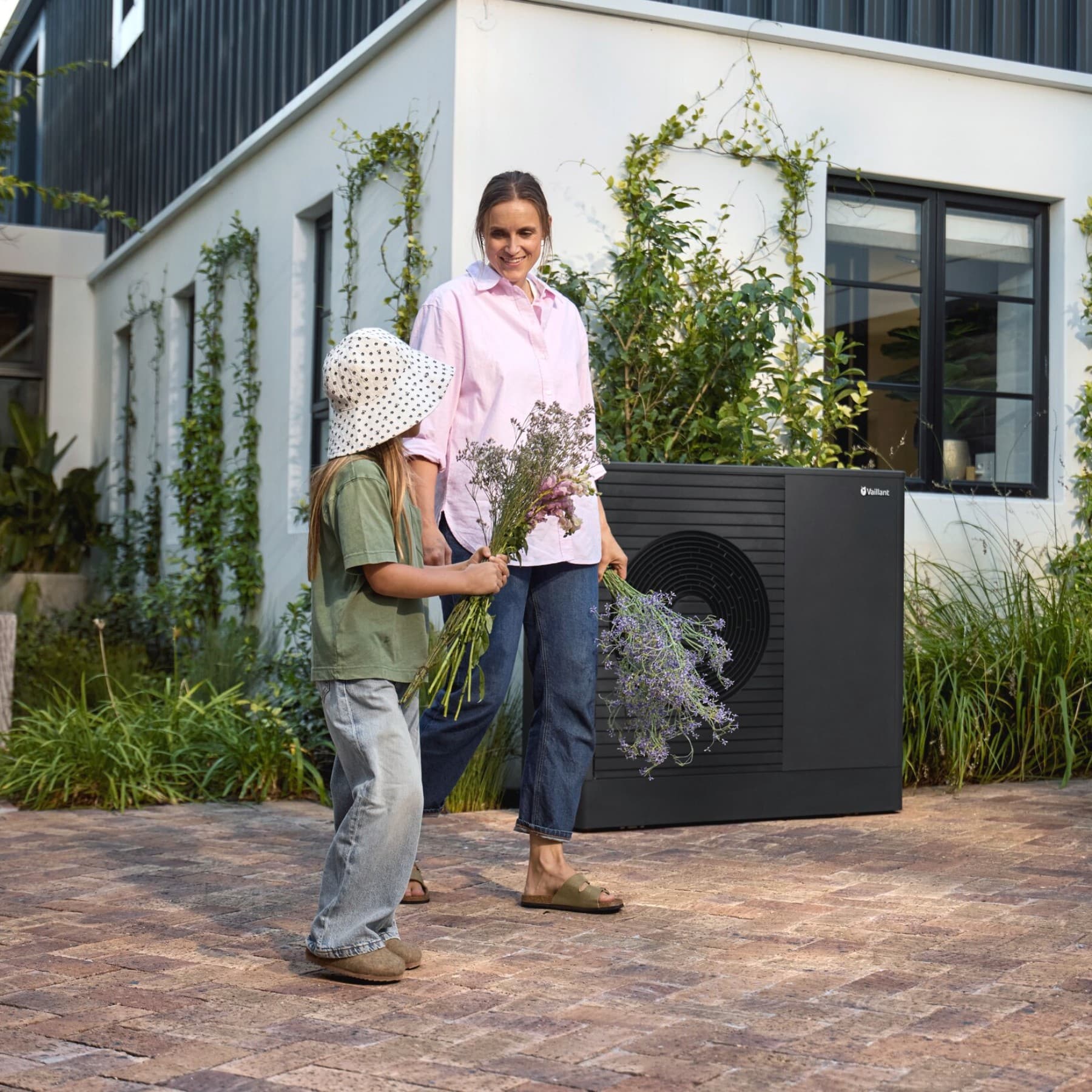 Mother and daughter in front of their heat pump