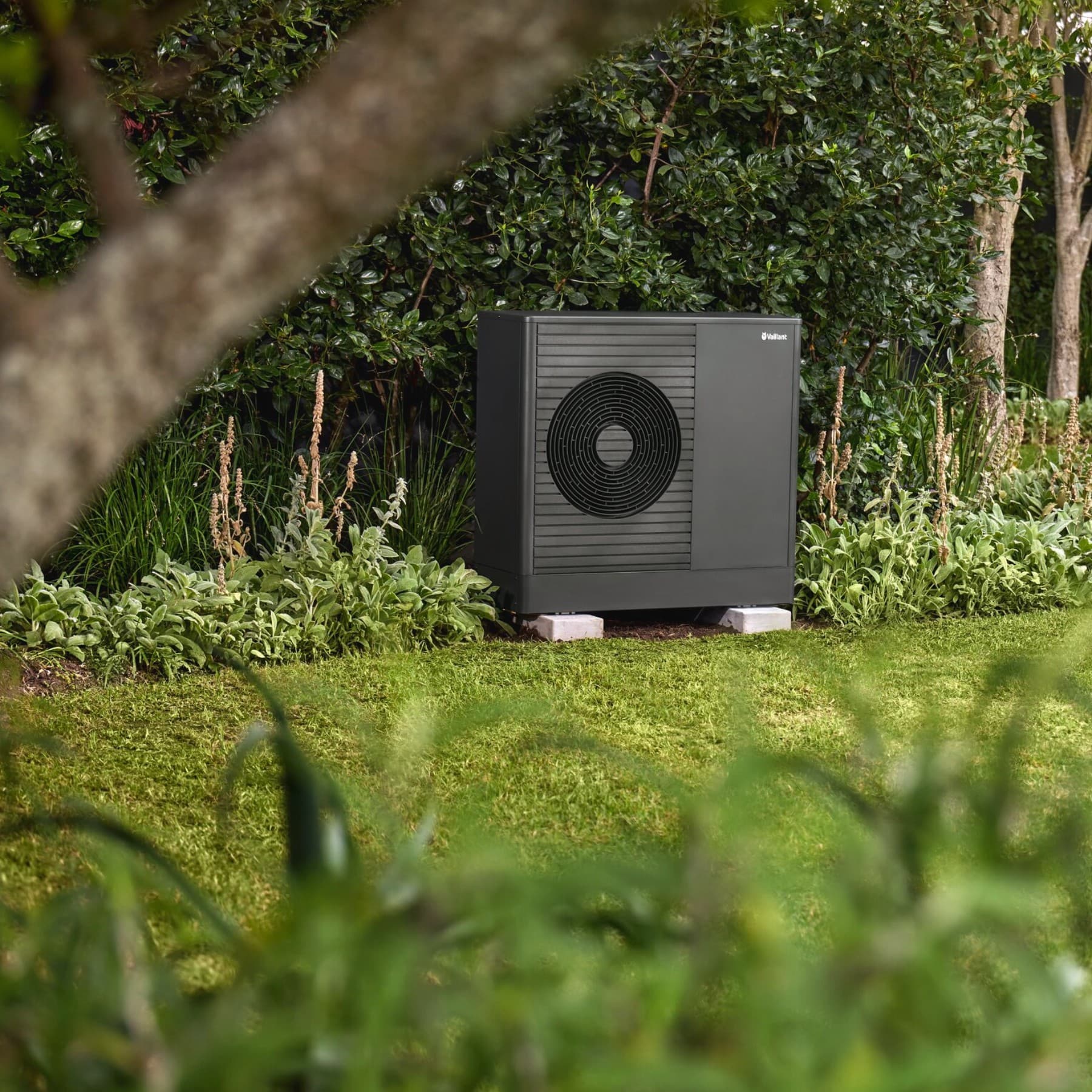 Vaillant heat pump in the garden in front of a house.