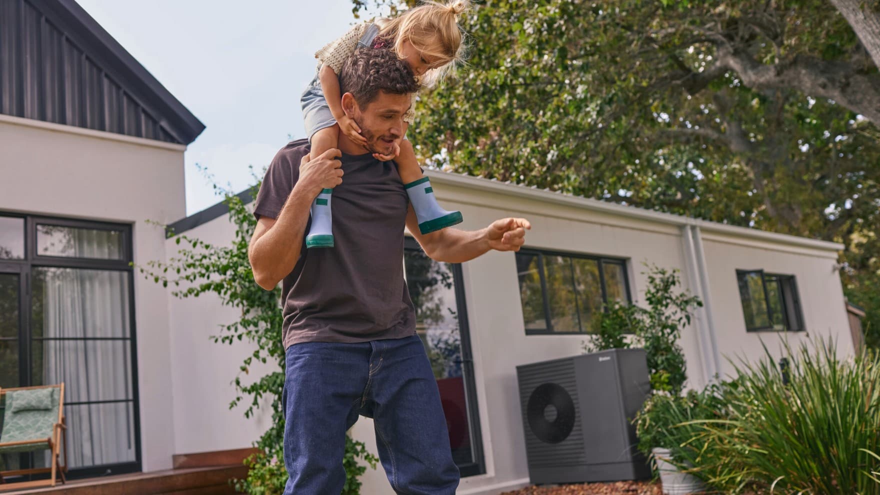 Dad and daughter in front of a heat pump