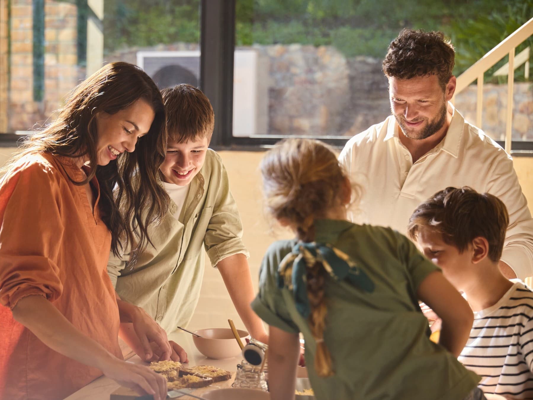 A family cutting a cake in their kitchen