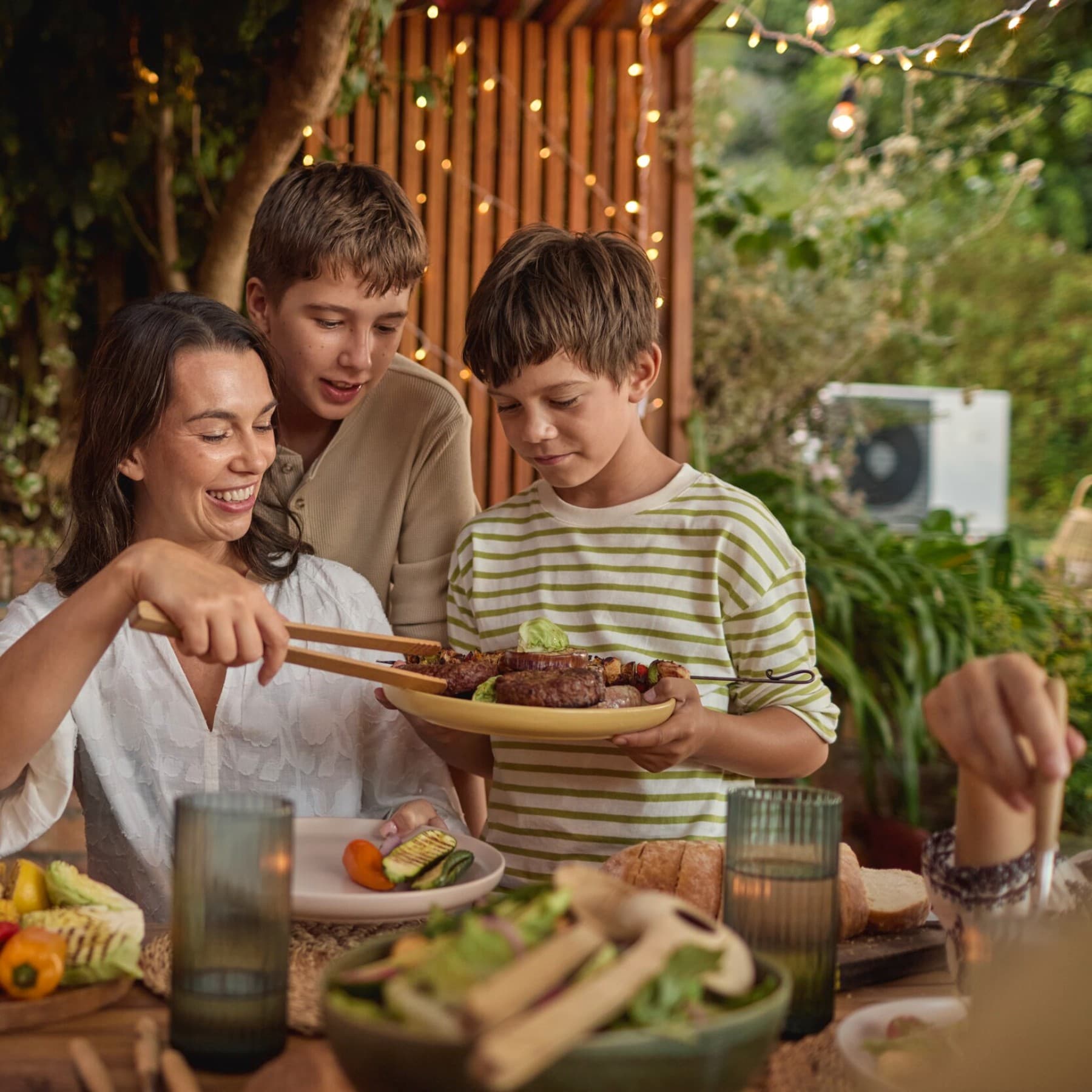 Une famille fait un barbecue dans le jardin
