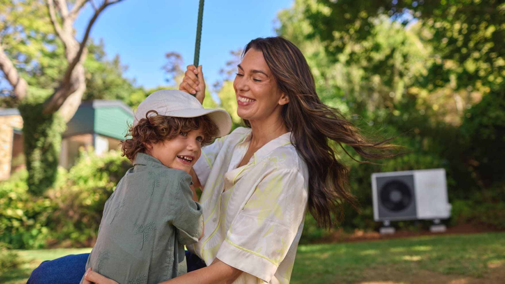Mother and son in the garden in front of their heat pump