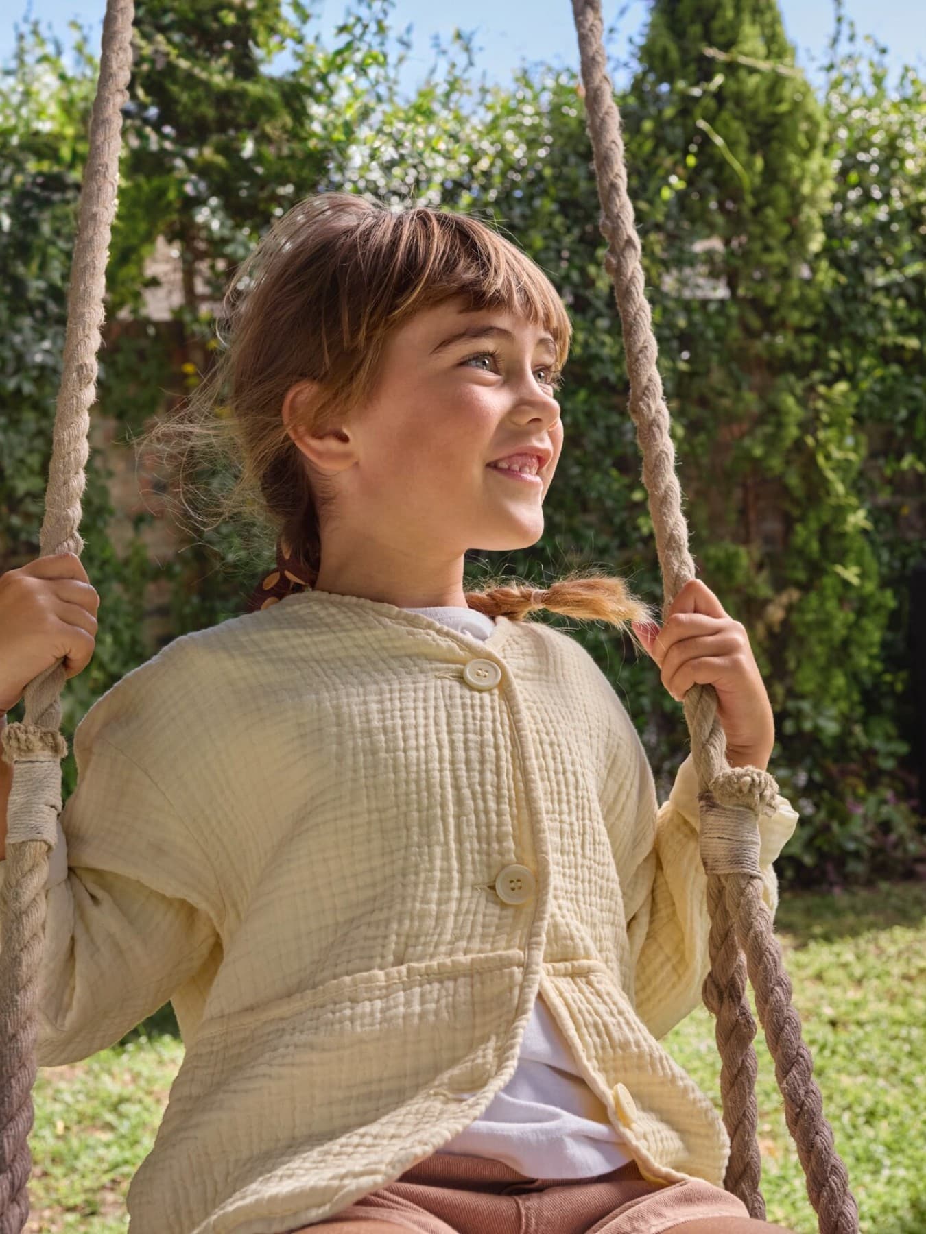 Children on a swing with a heat pump in the background