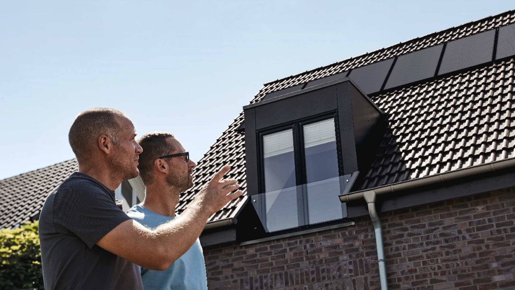 Craftsmen and the homeowner inspect the renovated roof.