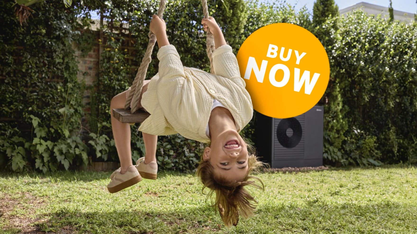 Child on a swing in the garden in front of a heat pump