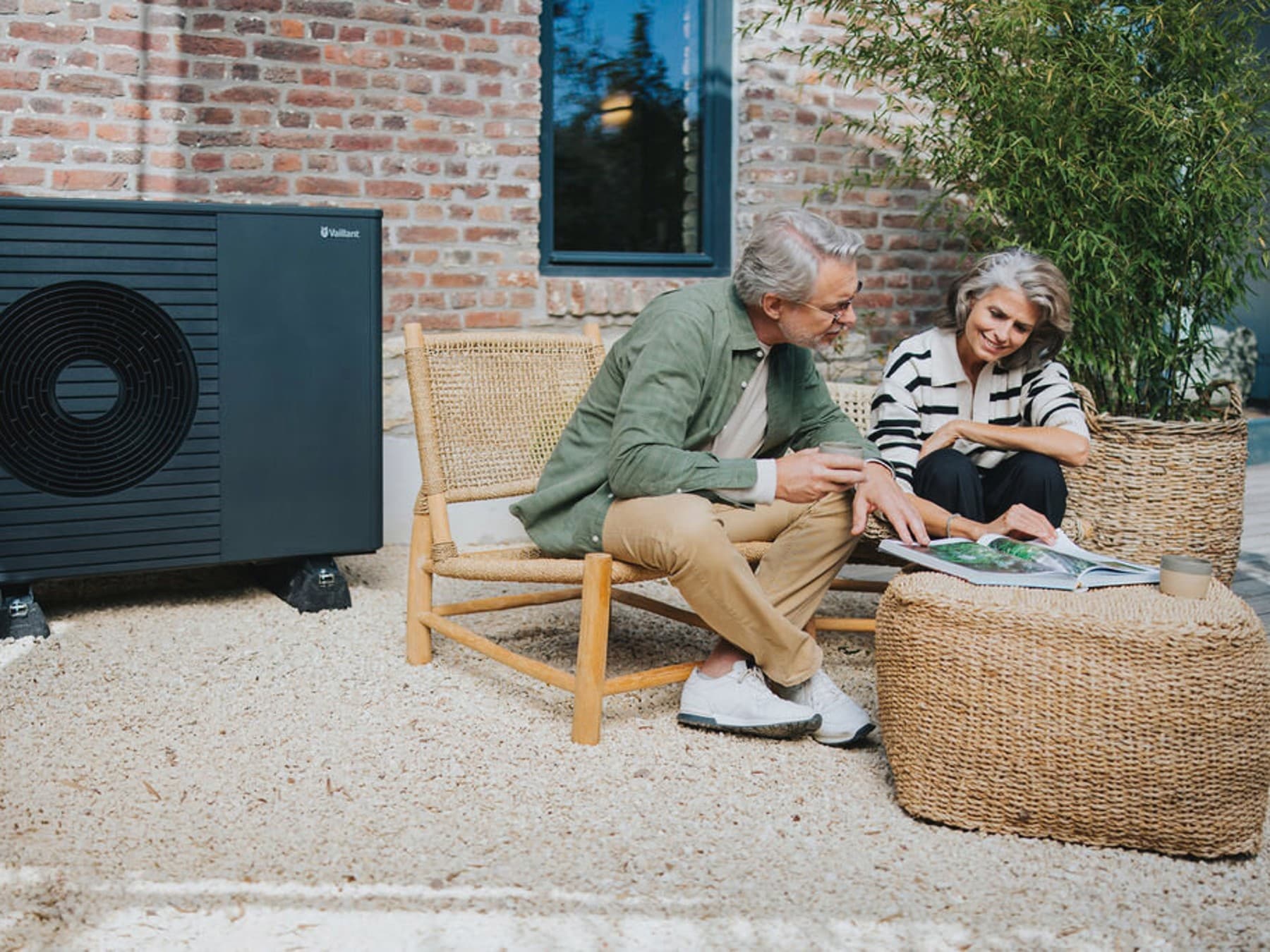Couple sitting outside next to a heat pump