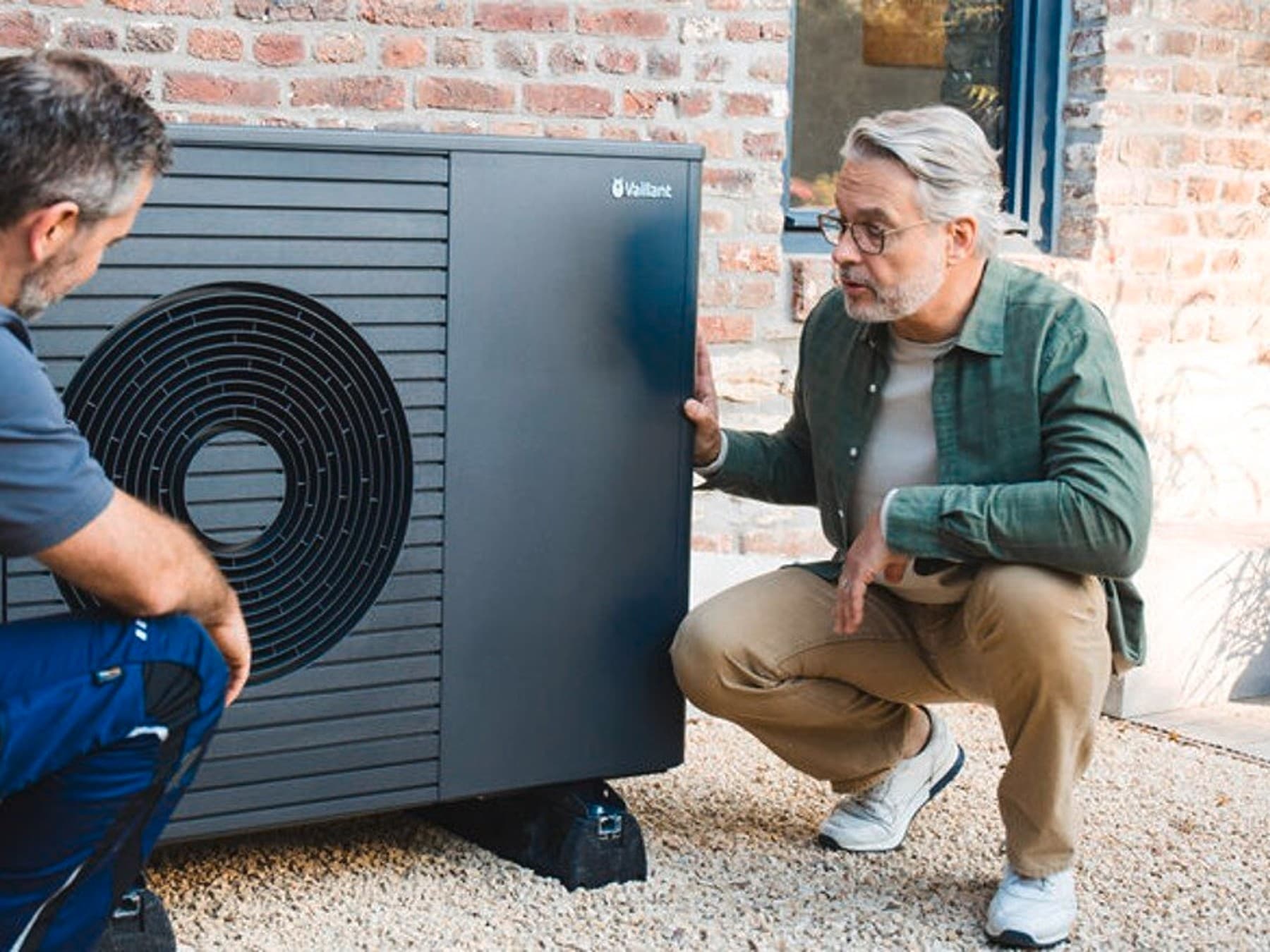 installer and houseowner next to a heat pump