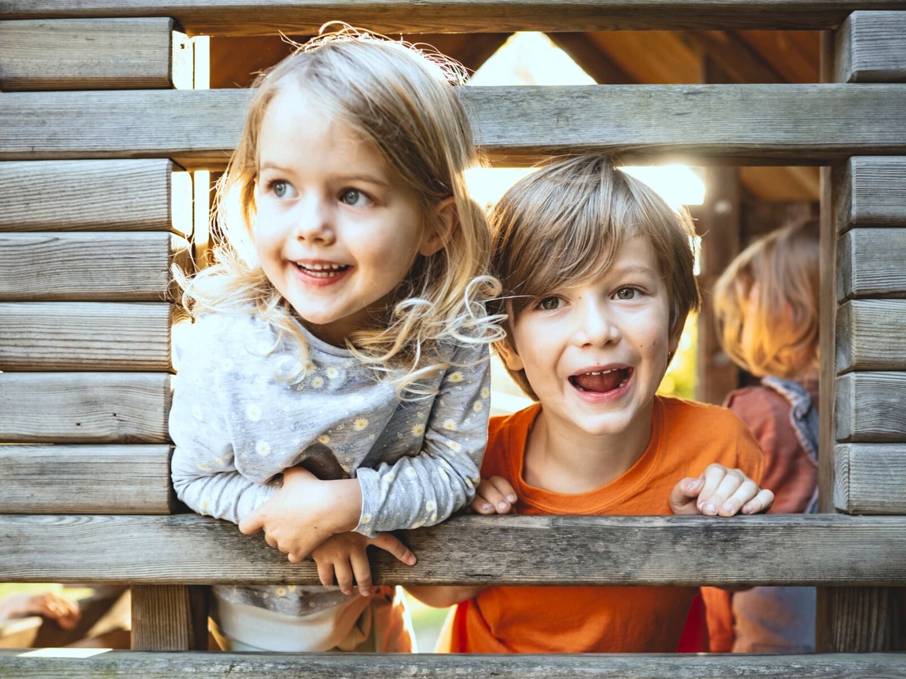 Deux enfants jouant dans une cabane en bois dans une aire de jeux