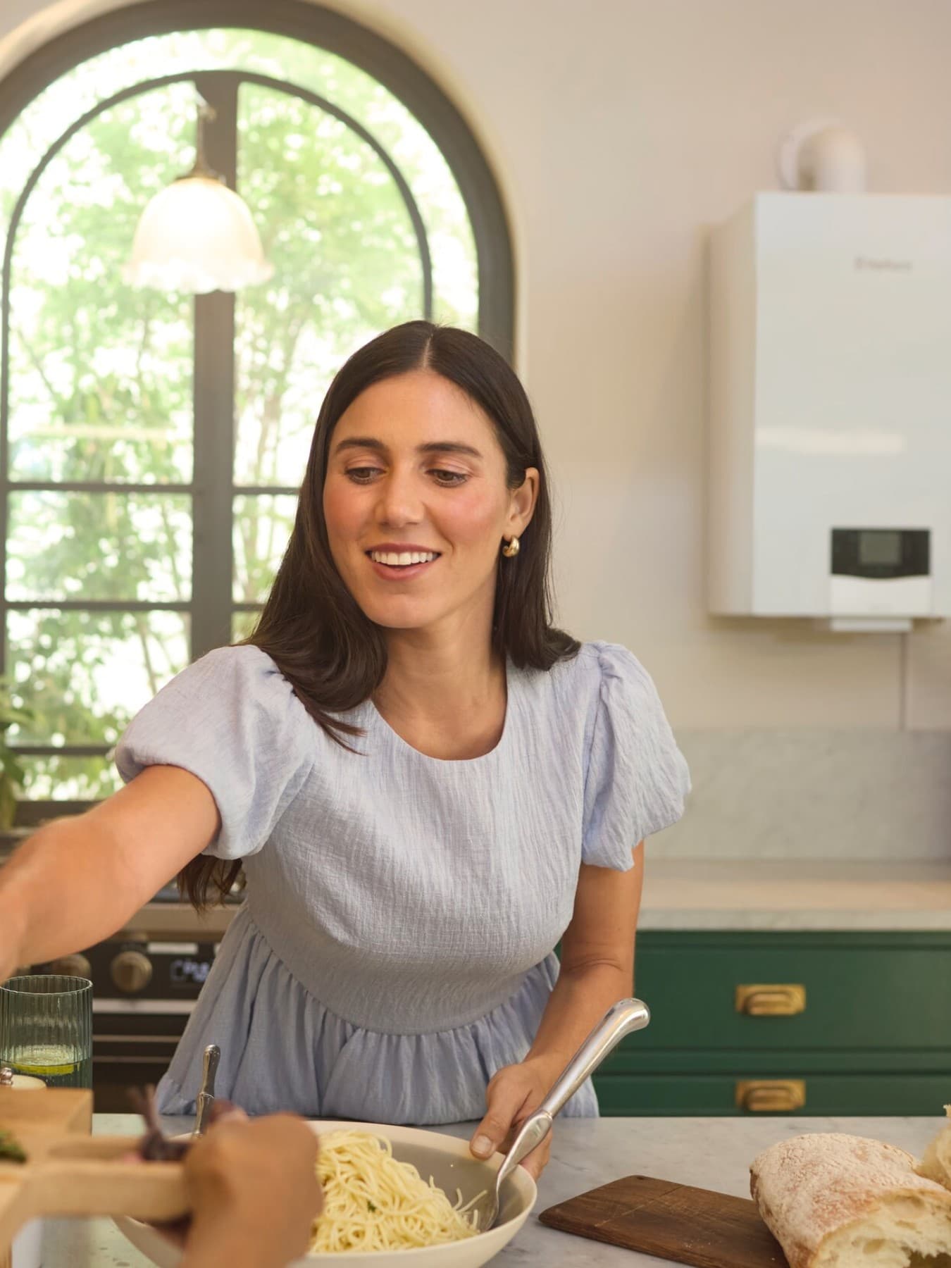 Woman in a kitchen in front of a boiler
