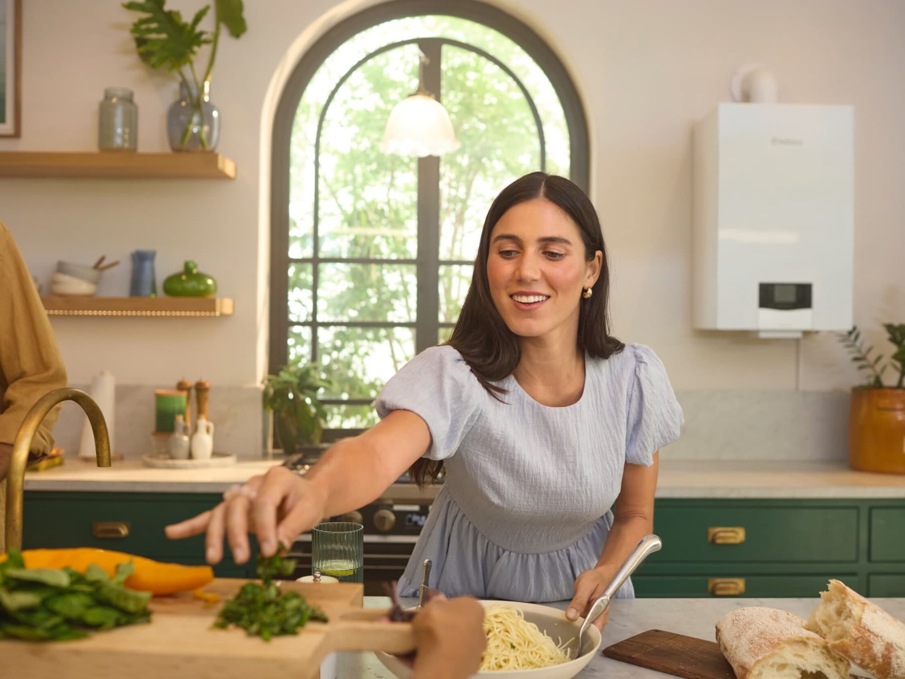 Woman cooking in the kitchen, with a gas boiler visible in the background.