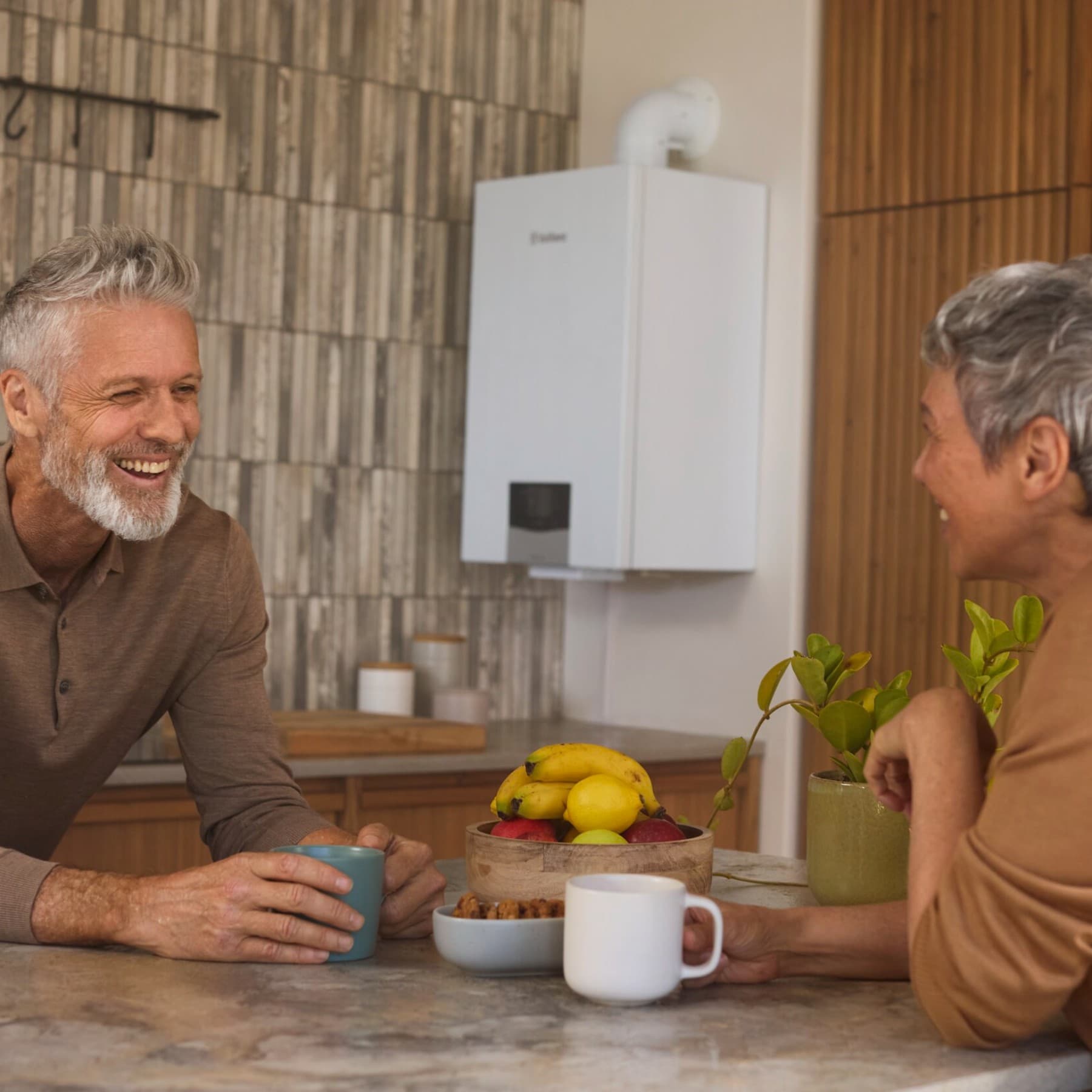 A couple smiling in front of a boiler