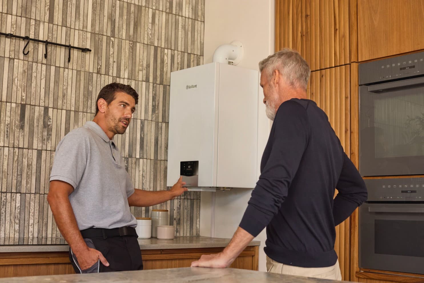 An installer explaining a boiler to a customer