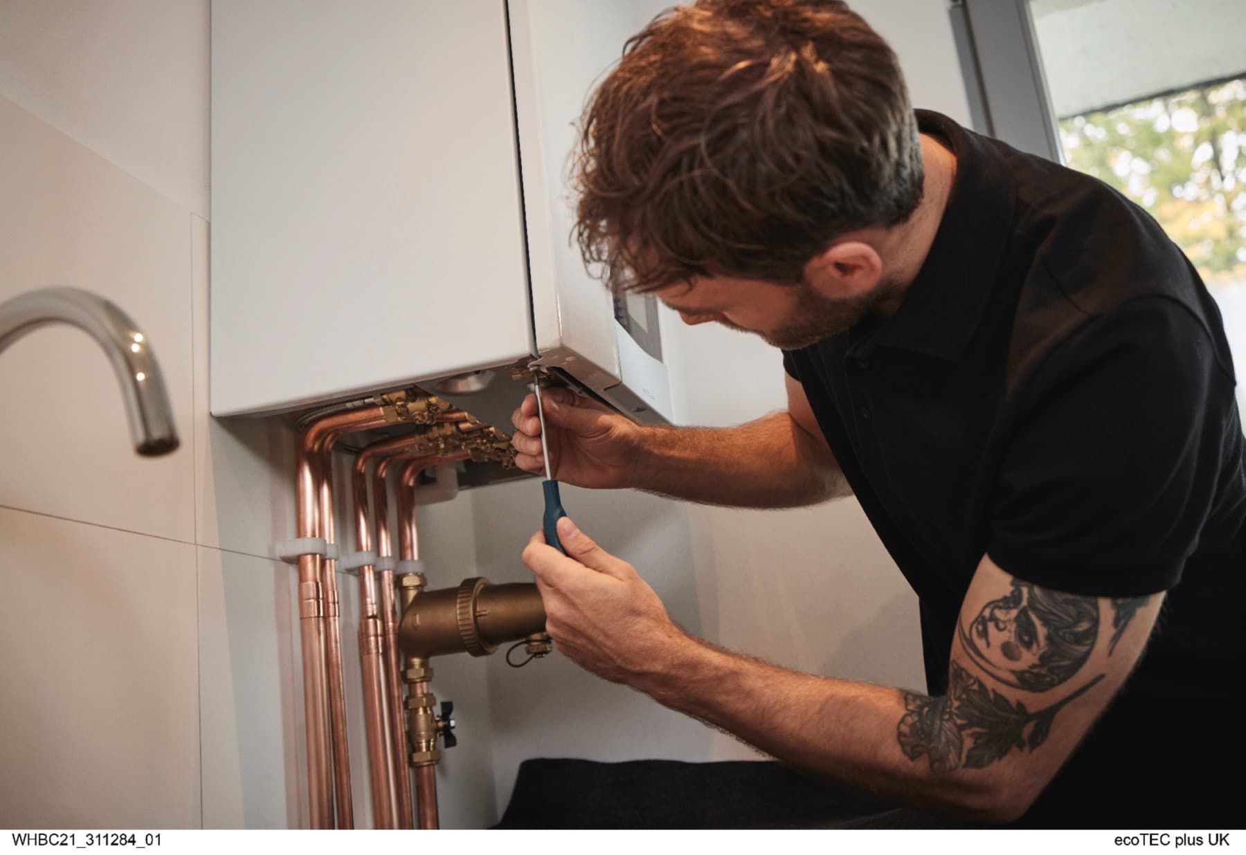 Installer screws on boiler