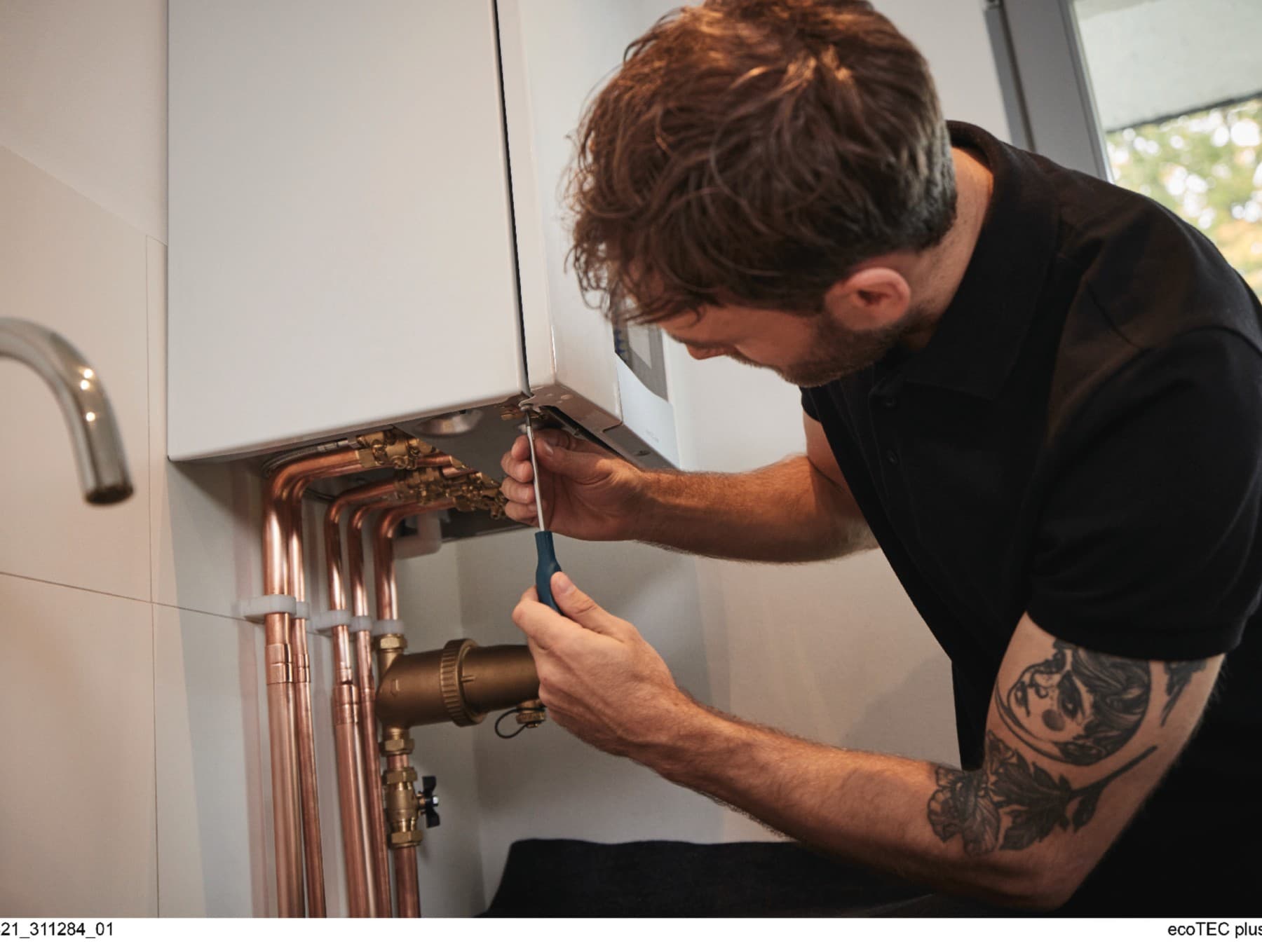 Installateur travaillant sur une chaudière